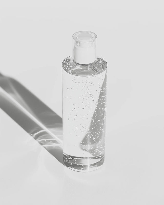 Clear glass bottle with a dropper on a light gray background