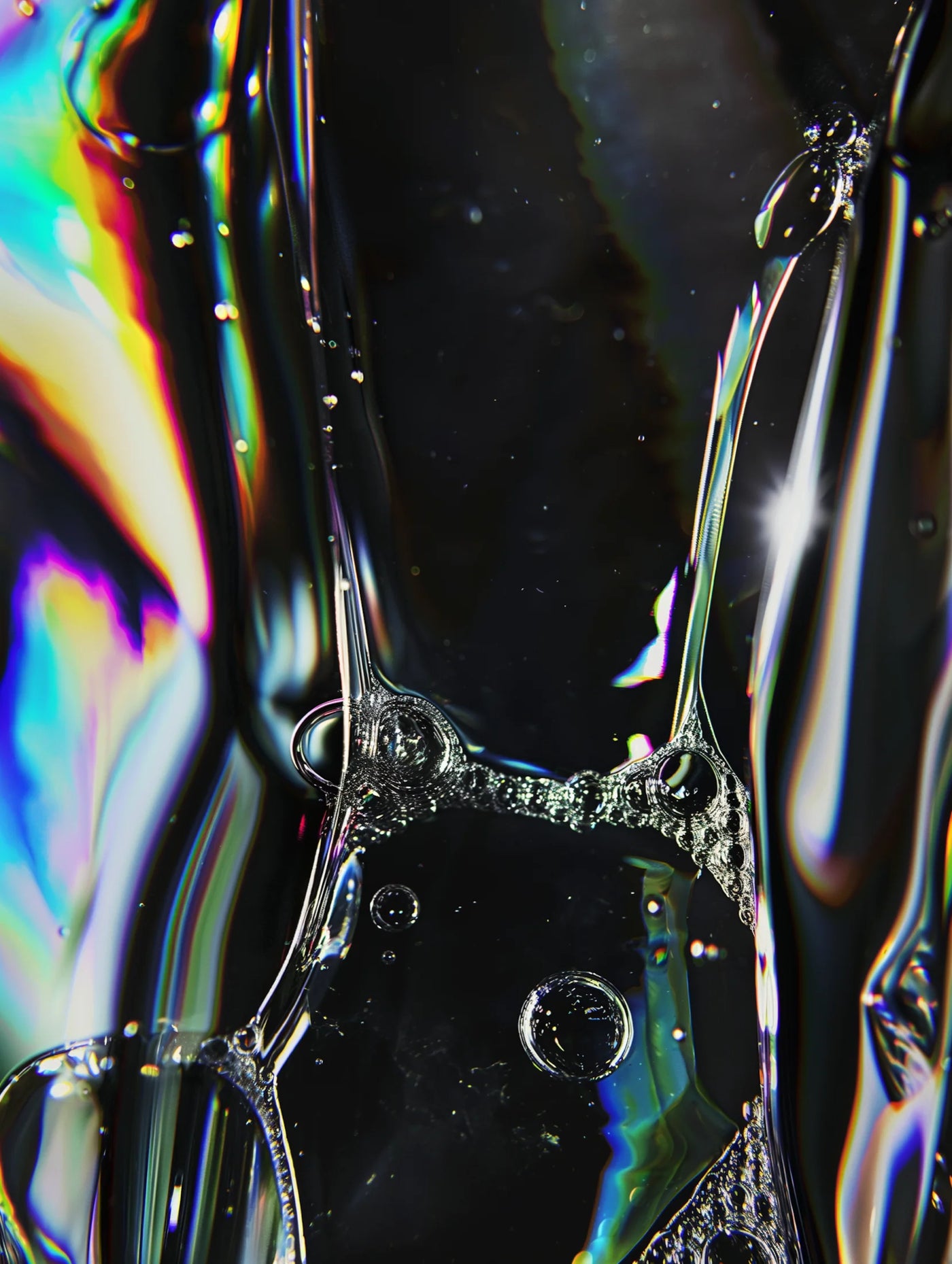 Close-up of iridescent liquid droplets on a reflective surface