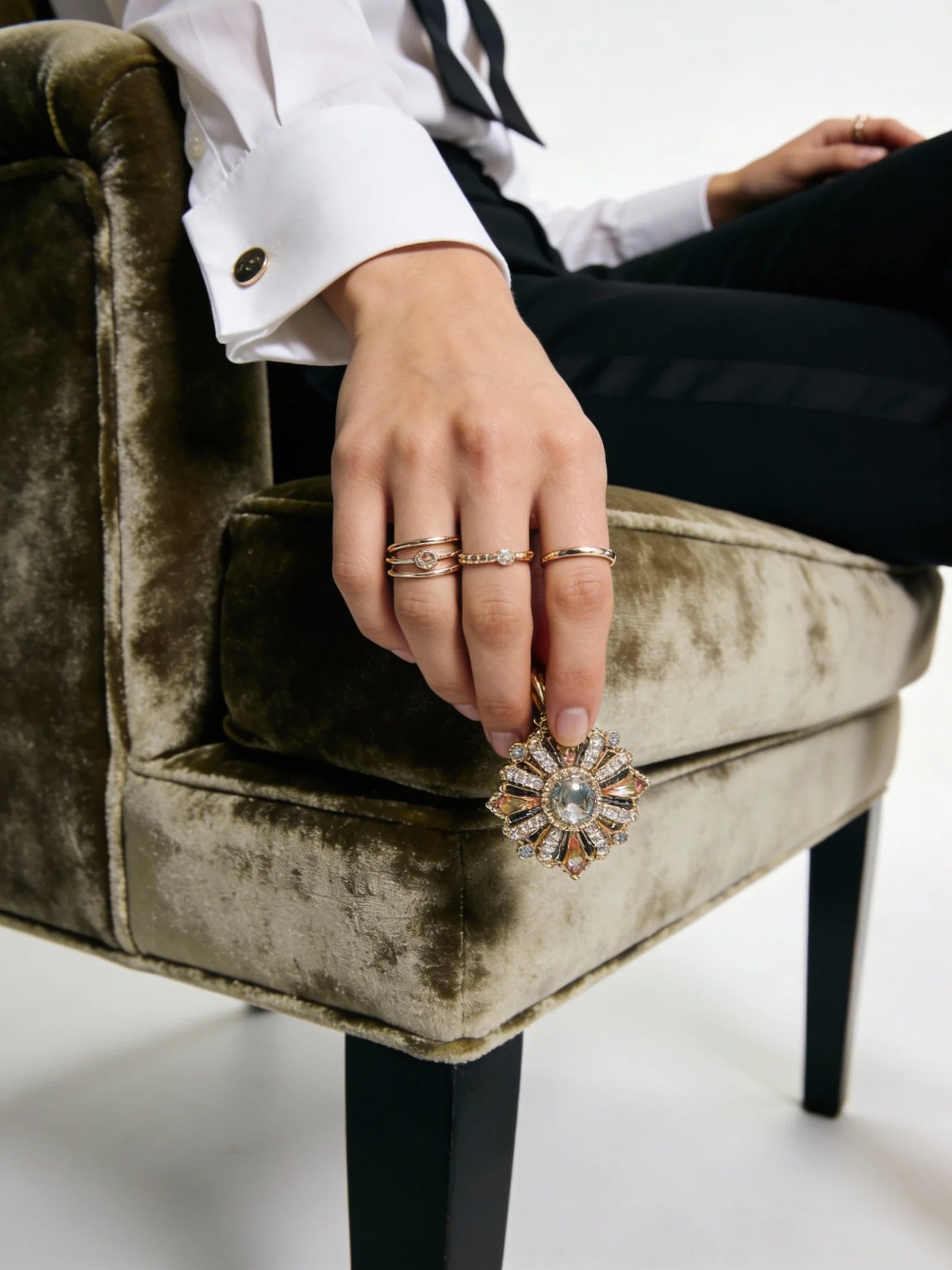 Person holding a decorative ring on a textured chair