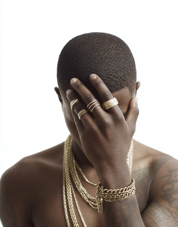 Person wearing gold jewelry with a plain background