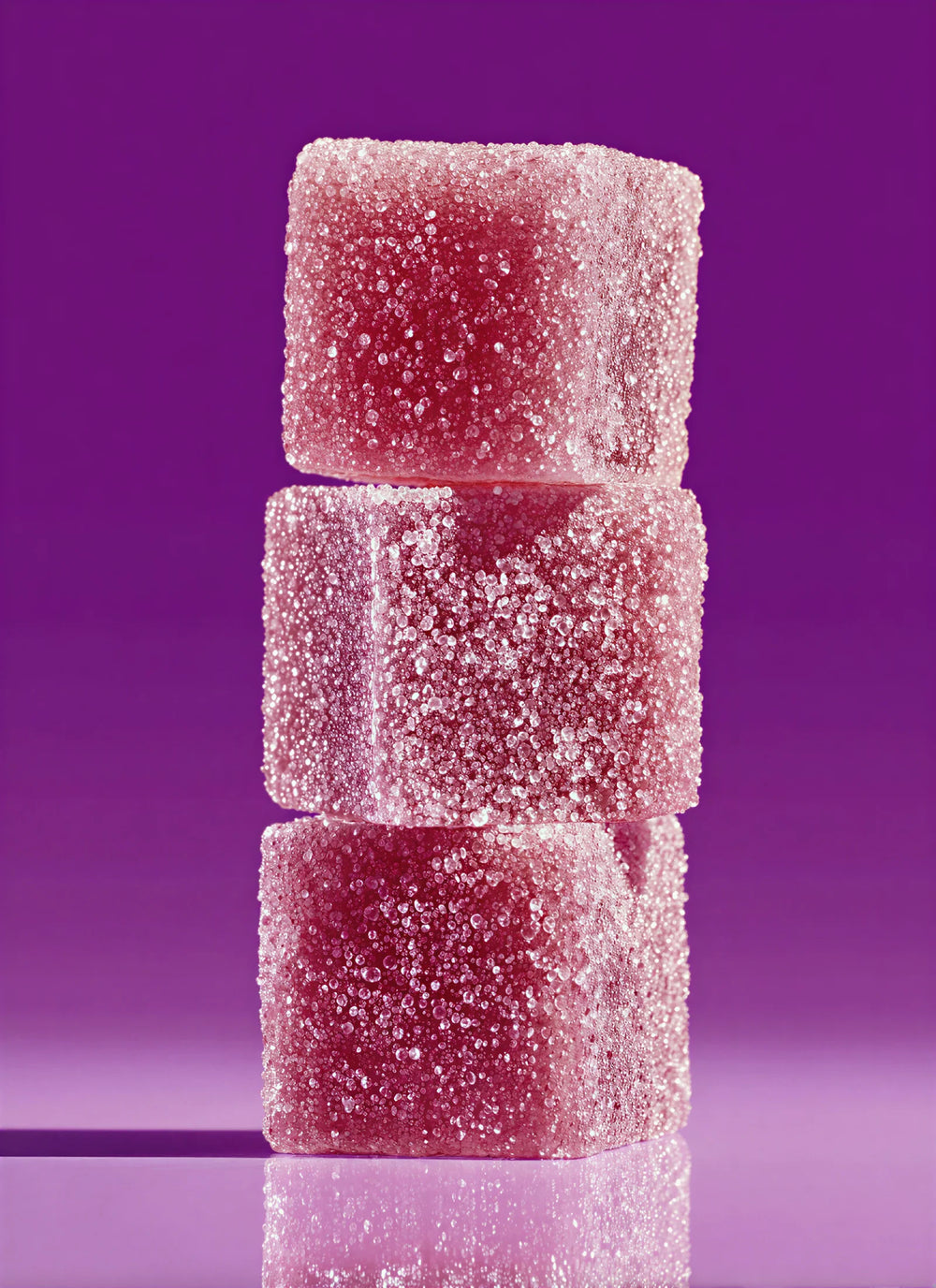 Stack of pink gummy cubes on a purple background