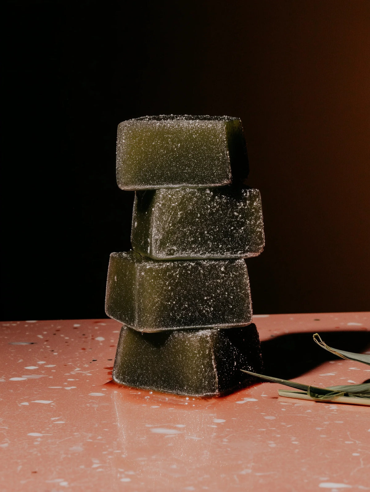 Stack of green matcha bars on a dark surface