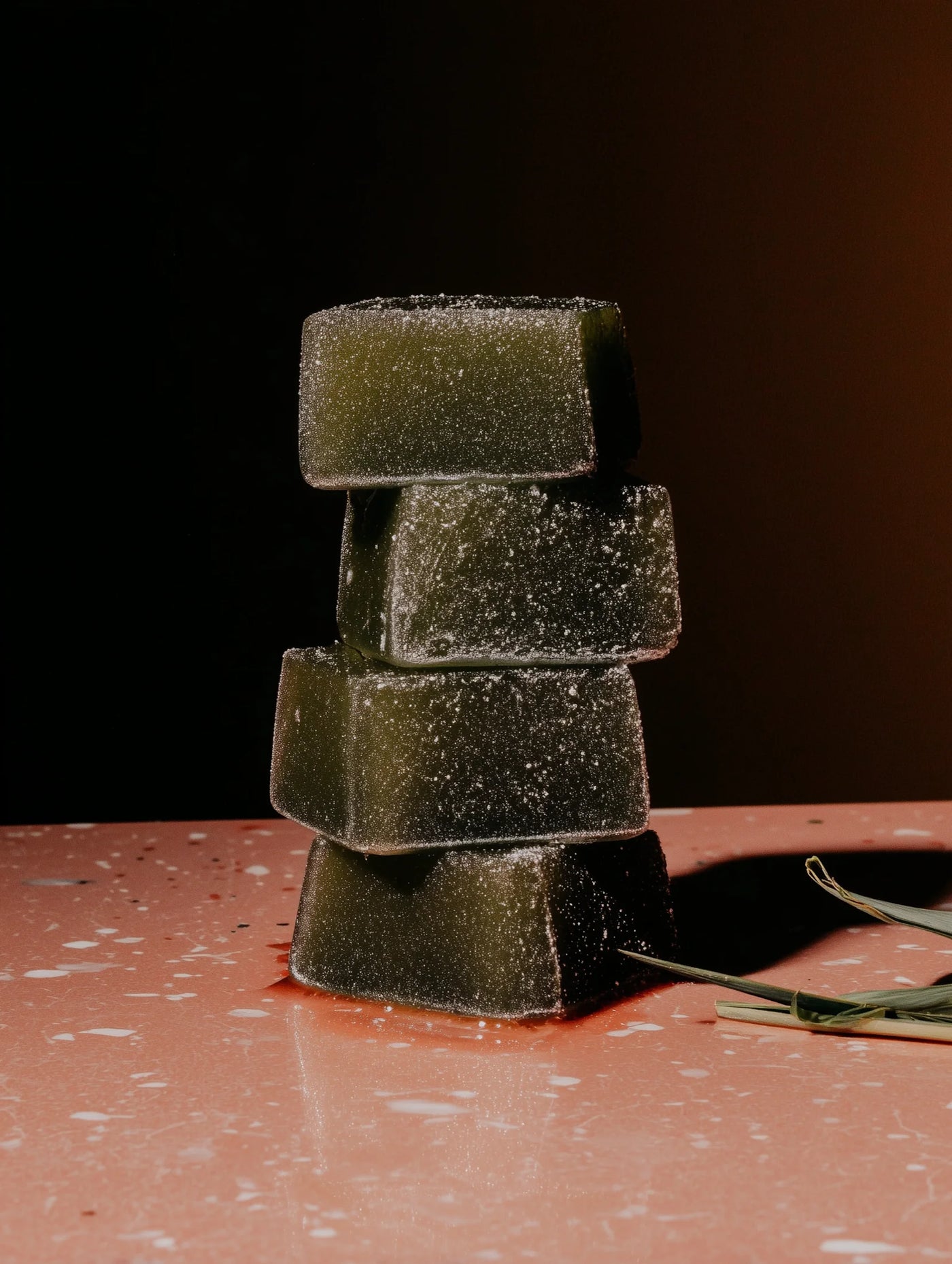 Stack of green matcha bars on a dark surface