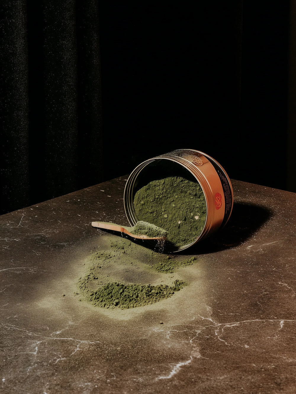 Spilled can of matcha on a dark surface with a black background