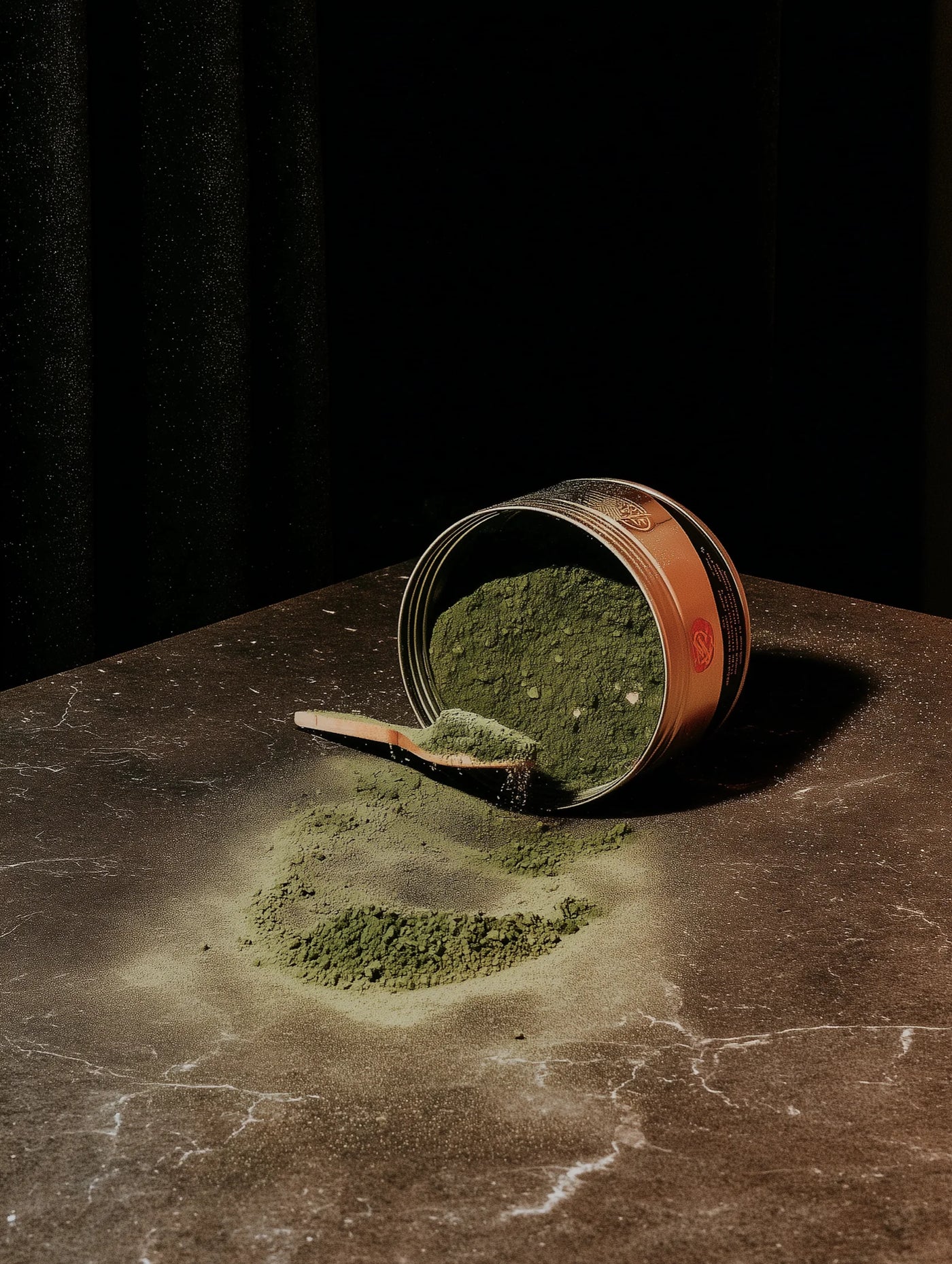 Spilled can of matcha on a dark surface with a black background