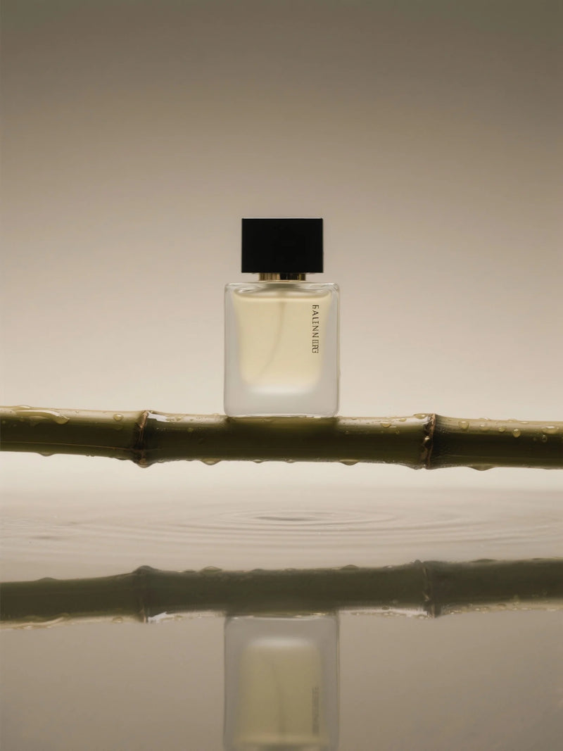 Perfume bottle on a branch with a neutral background