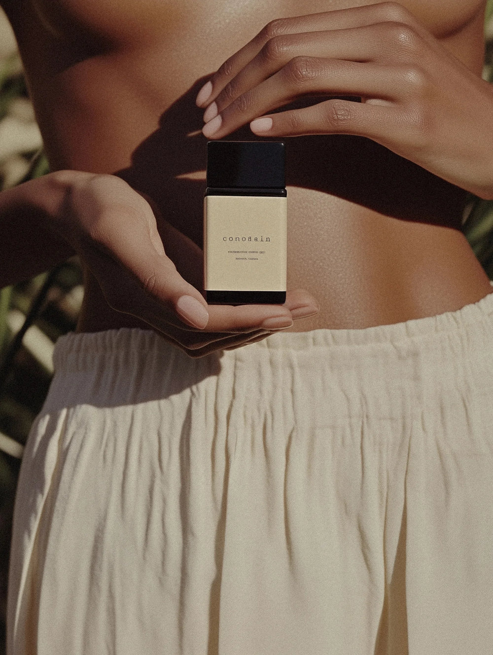 Person holding a Constance perfume bottle with a blurred background