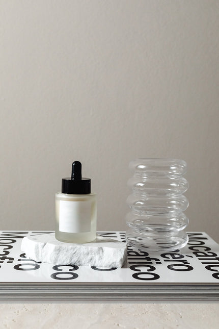 Blank product dropper bottle on coffee table book